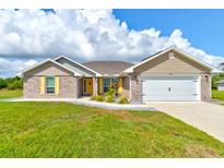 Beautiful single-story brick home with well-maintained lawn and attached two car garage at 208 Lagoon Mist Ct, Oak Hill, FL 32759