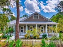 Charming home with a welcoming front porch, white picket fence, and beautifully landscaped front yard at 2656 Old Smyrna Trl, New Smyrna Beach, FL 32168