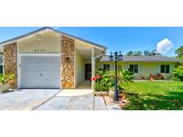 Charming single-story home featuring a stone accent wall, well-manicured lawn, and inviting curb appeal at 2914 Sabal Palm Dr, Edgewater, FL 32141