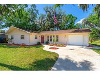 Charming single-story home with a well-manicured lawn and an American flag waving proudly at 3016 Mango Tree Dr, Edgewater, FL 32141