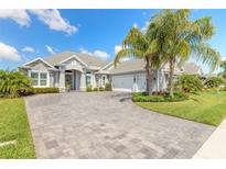 Beautifully landscaped single-Gathering home with paver driveway and lush tropical landscaping at 3219 Modena Way, New Smyrna Beach, FL 32168