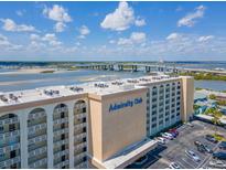Aerial view of the Admiralty Club condo building, revealing waterfront views and ample parking at 3606 S Peninsula Dr # 703, Port Orange, FL 32127