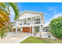 Charming elevated home featuring a front porch, garage, and well-maintained landscaping at 4009 S Peninsula Dr, Wilbur By The Sea, FL 32127