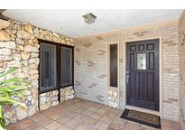 Charming front entryway with unique stonework, brick accents, tile flooring, and stylish wood door at 4431 Doris Dr, New Smyrna Beach, FL 32169