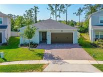 Charming single-story home with a well-manicured lawn and a brick paver driveway at 5607 Estero Loop, Port Orange, FL 32128
