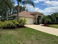 Charming single-story home with lush landscaping, a two-car garage and well-maintained lawn at 6093 Sabal Creek Blvd, Port Orange, FL 32128