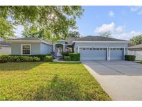 Charming single-story home featuring a three-car garage, manicured lawn, and a welcoming front entrance at 634 Woodford Dr, Debary, FL 32713