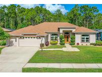 Charming single-story home featuring a well-manicured lawn, mature landscaping, and a welcoming front entrance at 6436 Longlake Dr, Port Orange, FL 32128