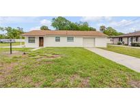 Charming single-story home featuring a well-maintained lawn and an attached one car garage at 701 West St, New Smyrna Beach, FL 32168