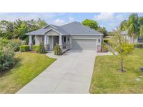 Charming one-story home with gray exterior, manicured landscaping, and a two-car garage at 1100 Loch Linnhe Ct, New Smyrna Beach, FL 32168