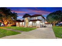 Stunning two-story home featuring a red tile roof, a well-manicured lawn, and a spacious driveway at sunset at 2813 Ballard Ave, Orlando, FL 32833