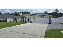 Charming single-story home with solar panels, two-car garage, and a well-maintained lawn at 2820 Tamarind Dr, Edgewater, FL 32141