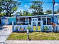 Charming home featuring a white picket fence, well-manicured lawn, and light blue exterior at 650 S Pine St, New Smyrna Beach, FL 32169