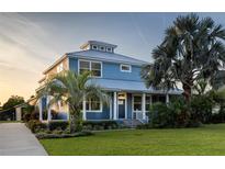 Stunning two-story home with metal roof, lush landscaping, and a charming covered porch at 1787 Earhart Ct, Port Orange, FL 32128