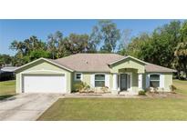 Charming single-story home with a well-manicured lawn and attached two-car garage at 2204 Kumquat Dr, Edgewater, FL 32141