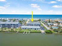 Stunning aerial view of waterfront condos featuring private docks and ocean access in a desirable coastal community at 845 Ladyfish Ave # B204, New Smyrna Beach, FL 32169
