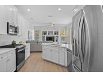 Bright kitchen featuring white cabinetry, stainless steel appliances and an island with a sink at 11222 Rapallo Ln, Windermere, FL 34786