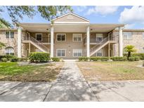 Inviting condo building features a manicured lawn and exterior stairs to the second-floor units at 160 Reserve Cir # 204, Oviedo, FL 32765