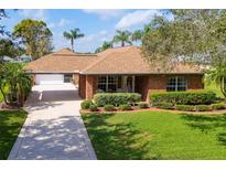Charming single-story brick home with a well-manicured lawn and mature landscaping at 1688 Town Park Dr, Port Orange, FL 32129
