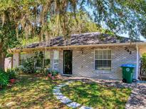 Charming one-story home with a well-manicured lawn, quaint stepping stones, and a brick facade at 242 Cypress Ave, Oak Hill, FL 32759