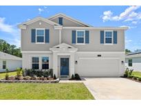 Charming two-story home featuring blue shutters, a manicured lawn, and a two-car garage at 2516 Hoptree Ln, Edgewater, FL 32141