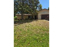 Charming single-story home with a well-maintained lawn and mature trees, perfect for a peaceful suburban lifestyle at 2725 Travelers Palm Dr, Edgewater, FL 32141