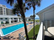Inviting pool area with palm trees and ocean views from condo balcony at 4225 S Atlantic Ave # 218, New Smyrna Beach, FL 32169