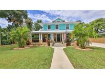 Charming two-story home with well-manicured lawn and inviting front porch with traditional landscaping at 508 Faulkner St, New Smyrna Beach, FL 32168