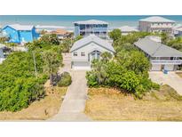 Charming two-story beach home featuring lush tropical landscaping and ample parking at 6361 Turtlemound Rd, New Smyrna Beach, FL 32169
