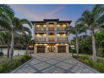 Stunning three-story home boasting multiple balconies and a beautifully paved driveway lined with palm trees at 6771 Turtlemound Rd, New Smyrna Beach, FL 32169