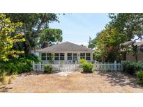 Charming single-story home featuring a white picket fence and lush landscaping at 825 E 23Rd Ave, New Smyrna Beach, FL 32169