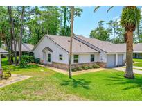 Charming single-story home featuring a well-maintained lawn, brick accents, and an attached single-car garage at 115 Bob White Ct, Daytona Beach, FL 32119