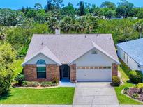 Charming single-story home featuring a brick facade, well-manicured lawn, and a two-car garage at 1307 Wayne Ave, New Smyrna Beach, FL 32168
