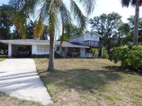 Two-story home featuring an attached carport, first floor porch, and second story balcony at 1627 Umbrella Tree Dr, Edgewater, FL 32132