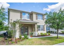 Two-story home featuring tidy landscaping, neutral colors, and a charming front porch with decorative columns at 1674 Coulter Ln, Port Orange, FL 32129