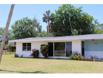 Charming single-story home with white brick exterior and well-maintained lawn at 1830 Needle Palm Dr, Edgewater, FL 32132