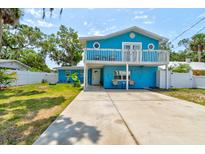 Bright blue two-story home featuring a second-story balcony, quaint curb appeal, and ample parking at 184 Azalea Rd, Edgewater, FL 32141