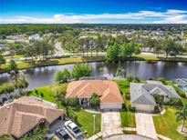 Stunning aerial view of waterfront home with mature trees, lush landscaping, and a serene water view at 1840 Tara Marie Ln, Port Orange, FL 32128