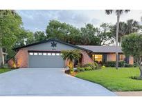 Charming brick home with a well-manicured lawn, a two-car garage, and mature landscaping at 208 Wellington Dr, Daytona Beach, FL 32119