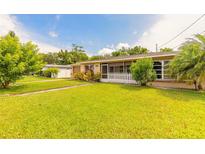 Charming home featuring a well-manicured lawn, mature trees, and a quaint white picket fence at 306 Jefferson Ave, Port Orange, FL 32127