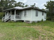Charming single-story home with a metal roof, front porch, and wood siding at 3625 Pioneer Trl, New Smyrna Beach, FL 32168