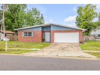 Charming single-story home with a brick facade, blue accents, and a spacious two-car garage at 3718 Paige St, Port Orange, FL 32129