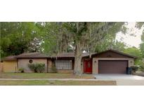 Charming brick home with a well-manicured lawn and a beautiful tree in the front yard at 3736 Paige St, Port Orange, FL 32129