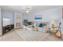 Bright living room with modern decor, ceiling fan and fireplace at 3808 Saxon Dr, New Smyrna Beach, FL 32169