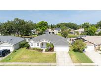Beautiful single-story home featuring a manicured lawn, two-car garage, and tropical landscaping at 404 Central Mariners Dr, Edgewater, FL 32141
