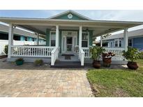 Charming home featuring a cozy covered front porch, manicured lawn and brick paver walkway at 415 Jessamine Ave, New Smyrna Beach, FL 32169