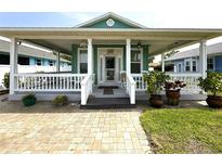 Charming home featuring a spacious covered front porch with white railings and decorative potted plants at 415 Jessamine Ave, New Smyrna Beach, FL 32169