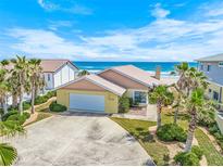 Charming beach home with a two-car garage, palm trees, and stunning ocean views from the front yard at 4323 S Atlantic Ave, Port Orange, FL 32127