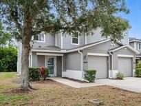 Two-story townhome featuring an attached garage, well-maintained landscaping, and neutral-tone facade at 567 Mount Olympus Blvd, New Smyrna Beach, FL 32168