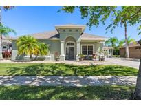 Charming single-story home with lush landscaping, a well-manicured lawn and beautiful tropical palm trees at 637 Marisol Dr, New Smyrna Beach, FL 32168